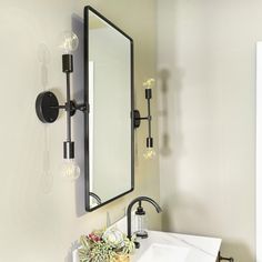 a bathroom with a sink, mirror and lights on the wall next to each other