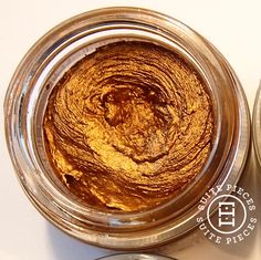 two jars filled with food sitting on top of a white table next to each other