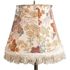 a table lamp with fringes and flowers on the lampshade is shown in this image