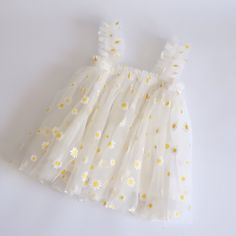 Stunning white tulle dress, with yellow daisy details Lined with a light white cotton fabric.  Perfect match with our daisy themed birthday party hats/crown Sizes 0 (6-12months) 1 (12-18months) PLEASE NOTE Children should be supervised at all times while wearing items. Some of our items contain small items which could become detached. Do not let them wear it whilst unattended or asleep. There may be slight variations in monitor colours. There may also be variations in pattern placement of fabric Daisy Themed Birthday Party, Daisy Birthday Party, White Tulle Dress, Daisy Birthday, White Cotton Fabric, Birthday Party Hats, Yellow Daisy, Dress Cake, White Tulle