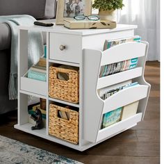 a white table with baskets and books on it next to a couch in a living room