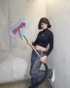 a woman holding a blow dryer in her right hand and posing for the camera