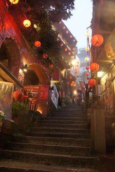 an alleyway with lanterns hanging from the ceiling and steps leading up to it's entrance