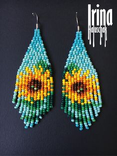 the earrings are made out of beads and beaded with an image of a bird