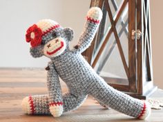 a crocheted sock monkey sitting on the floor