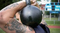 a man with tattoos holding a kettle in front of his face and back to the camera