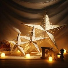 a lighted star next to some candles on a table