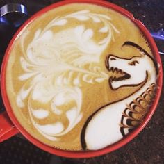 a cup of coffee with a drawing of a horse on it's foamy liquid