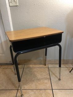 a small desk sitting on top of a tiled floor