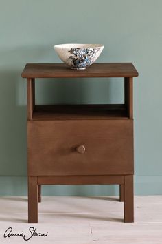 a bowl sitting on top of a wooden table next to a blue and white wall