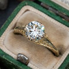 an antique diamond ring sits in its box