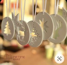 christmas ornaments hanging from strings on a table