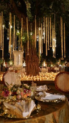 the table is set up with candles and plates for an elegant wedding reception at night