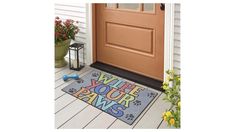 a welcome mat with the words wipe your paws on it next to a front door