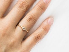 a woman's hand with a diamond ring on it