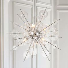 a chandelier hanging from the ceiling in a room with white walls and doors