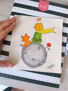 a drawing of a cat sitting on top of a rock in front of a person's hand