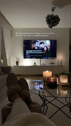 a living room with a large screen tv and candles on the table in front of it