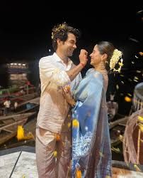 a man and woman standing next to each other on top of a roof with confetti thrown in the air