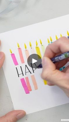 someone is drawing on a piece of paper with crayons and colored pencils