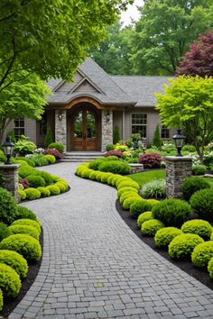 a stone walkway leading to a house surrounded by lush green trees