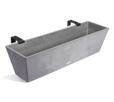 a large rectangular concrete tub with two faucets on the sides and one end