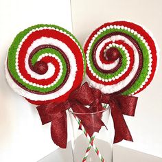 two candy lollipops sitting in a glass vase