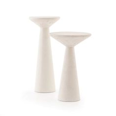 two white vases sitting next to each other on a white surface in front of a white background