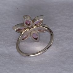 Our 14k white gold pink tourmaline birth flower ring is a birthstone ring & statement ring in one. This is a custom designed ring, which means it is one of a kind design. We love the floral theme in jewelry, as it is the ultimate in femininity, while being fun! Floral jewelry always makes me smile. We used 6 Marquise shaped gemstones for the petals and the center is a 3mm round gemstone. All gems are bezel set for stone security. The metal outlining the petals is given detail by hand. Let us mak Formal Pink Flower-shaped Rings, Formal Pink Flower Shaped Ring, Pink Rings With Polished Finish Fine Jewelry, Pink Gemstone Flower Ring For Formal Occasions, Fine Jewelry Pink Rings With Polished Finish, Formal Pink Gemstone Flower Ring, Pink Wedding Rings With Polished Finish, Floral Jewelry, All Gems