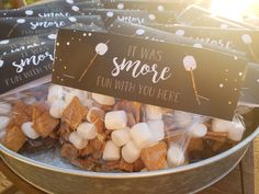 some marshmallows are in a metal bowl with a sign that says it was s'more fun with you here