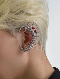 a woman with blonde hair wearing some kind of metal earring that has spikes on it