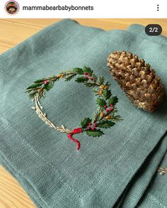 a pine cone is sitting on top of a blue napkin with a red ribbon around it