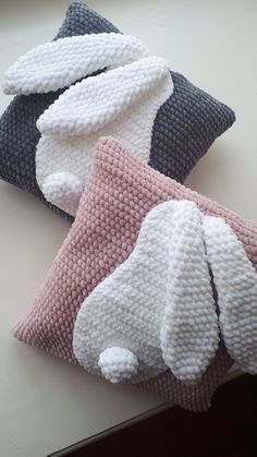 three knitted pillows sitting on top of a table