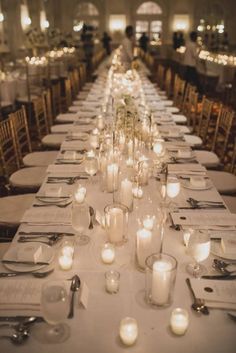 a long table is set with candles and place settings