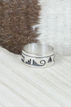 This sterling silver ring was made by Hopi silversmith Timothy Mowa. The inside is stamped sterling.Size: 10Length: 7/8"Width: 3/8"Free shipping on all orders! We ship with USPS and always include tracking. All orders ship within a day of payment.Returns are accepted up to 30 days after you receive your order. Just send us a message. Our shop offers cash back or store credit. The item must be returned in new condition. Stamped Sterling Silver Wide Band Jewelry, Symbolic Stamped Sterling Silver Rings, Symbolic Sterling Silver Stamped Rings, Artisan Sterling Silver Ring With Etched Details, Artisan Sterling Silver Etched Rings, Collectible Sterling Silver Ring With Wide Band, Adjustable Sterling Silver Ring With Inlay, Sterling Silver Stamped Rings For Collectors, Artisan Engraved Sterling Silver Ring 925