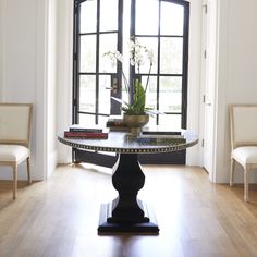 a living room with a table and chairs in front of a large window that looks out onto the yard