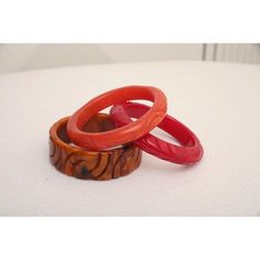 This is part of Chairish’s Costume Jewelry assortment.  The set of 3 art deco vintage authentic carved bangle bakelite bracelets are in the hues of red, amber orange and caramel. They are all hand carved and the orange caramel one is a thicker cuff with small swirls of black. The caramel on is 1.25" H x 3" W and the interior of that one is approx. 2.5" W. The other two are .5" H x 3.5" W and the other of those are 2.5" W. They will fit over a small medium wrist or medium wrist but not an extra w Red Retro Bangle Jewelry, Handmade Bakelite Bangle Bracelet, Vintage Orange Bangle Bracelets, Vintage Red Round Bangle, Vintage Amber Bangle Bracelet, Vintage Handmade Red Bangle, Red Carved Vintage Jewelry, Carved Red Vintage Jewelry, Handmade Bakelite Bracelets As Gift