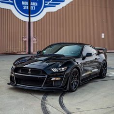 a black sports car parked in front of a building