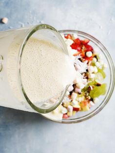 a glass filled with white liquid next to a salad