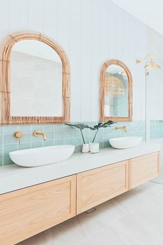 two sinks in a bathroom with mirrors and blue tiles on the wall behind them,