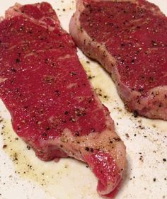 two pieces of meat on a plate covered in seasoning