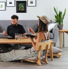 two people sitting at a table with drinks in front of them and one person holding a tablet