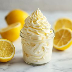 a glass jar filled with whipped cream next to sliced lemons