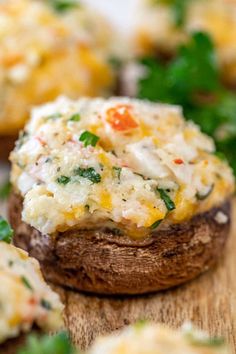 baked potatoes with cheese and spinach are on a wooden cutting board, ready to be eaten