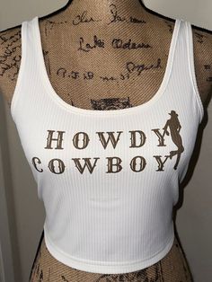 "\"Howdy Cowboy\" white tank top with cowgirl silhouette on the side! Also available in a dusty blue.  Perfect for summer time, bathing suit cover up! Any occasion! Breathable material. Western wear, country concert  Wash on cold, delicate setting, and flip inside out for longevity! Visit my page for similar styles!  Feel free to message me with any questions and I'm sure we can work something out! Ex. Can you do the letters in red instead?" Western Style Summer Tops With Letter Print, White Fitted Top For Western-themed Events, White Summer Tops For Rodeo, White Top For Rodeo Summer Events, White Tops For Summer Rodeo, Western Style Tops For Summer Western-themed Events, Western Style Tops For Summer Western Events, Fitted Western Tops For Summer, Western Style Fitted Sleeveless Tank Top