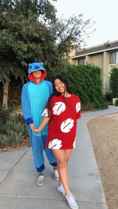 two people in costumes standing on a sidewalk