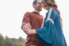 a man and woman holding hands while standing next to each other