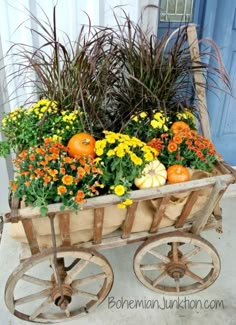 an old wagon filled with flowers and pumpkins