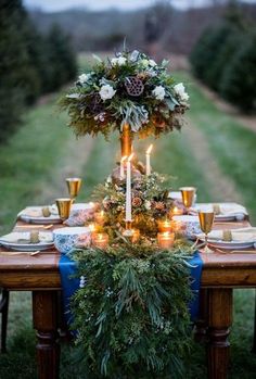 the table is set with candles and greenery