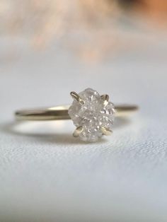 a white diamond ring sitting on top of a table